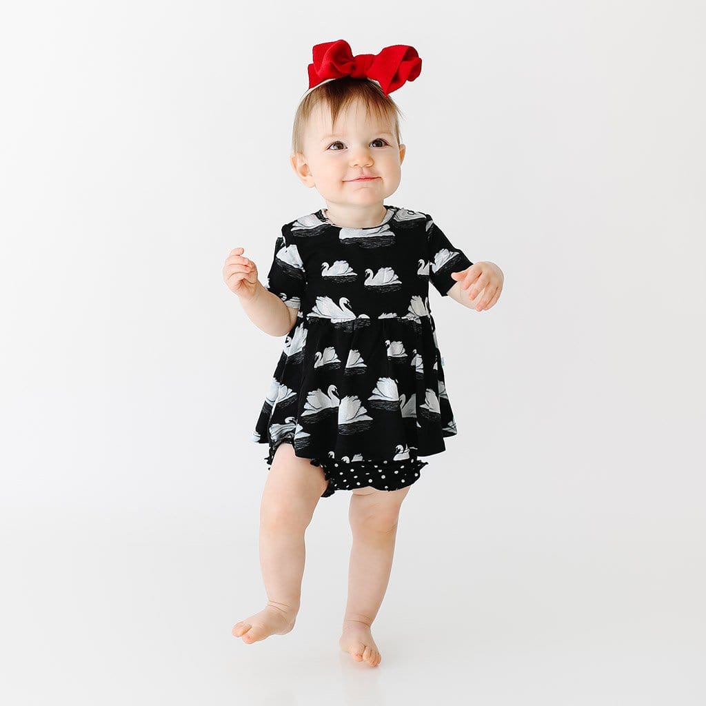Baby wearing Leia Short Sleeve Peplum Ruffled Bummie Set with swan pattern