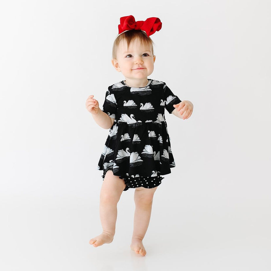 Baby wearing Leia Short Sleeve Peplum Ruffled Bummie Set with swan pattern