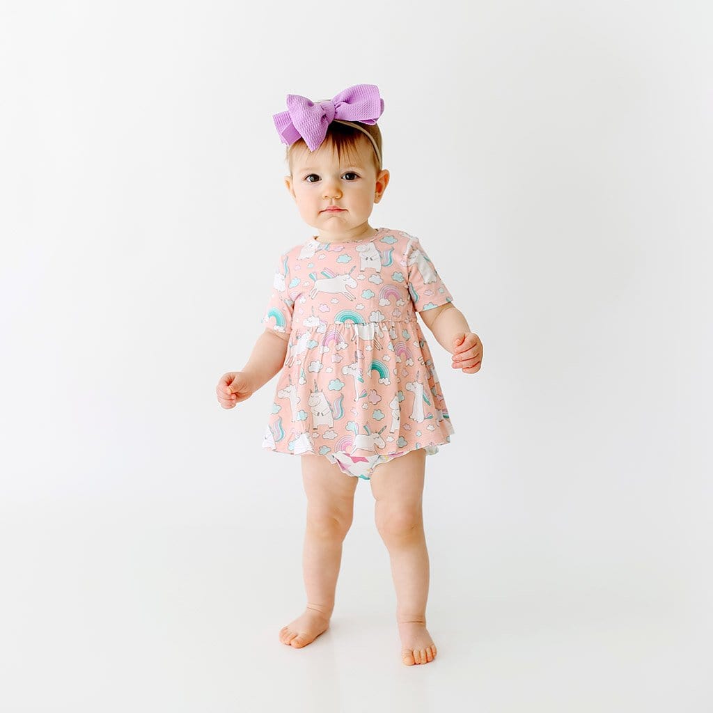 Toddler wearing pink Olive Short Sleeve Peplum Ruffled Bummie Set with unicorn pattern