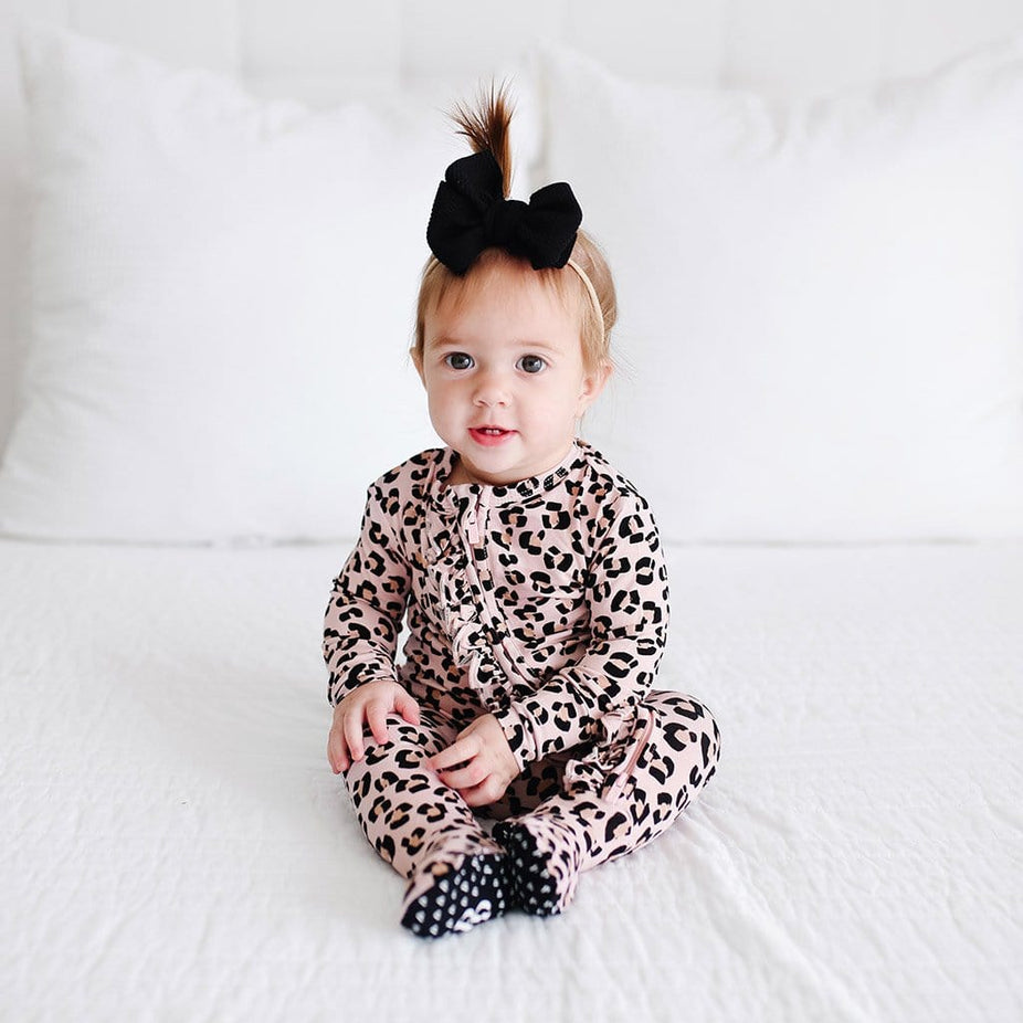 Baby sitting wearing Samara Footie Ruffled Zippered One Piece with jaguar pattern