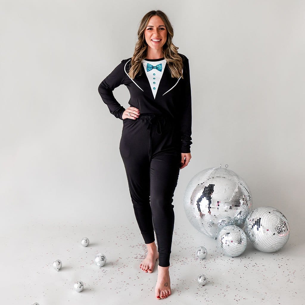 Woman in Tuxedo Pajamas for Women with New Year's Eve Ball behind her