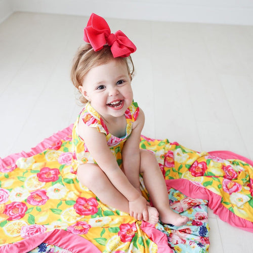 baby on red ribbon wearing Annika & Olivia Mae Ruffled Luxe Patoo