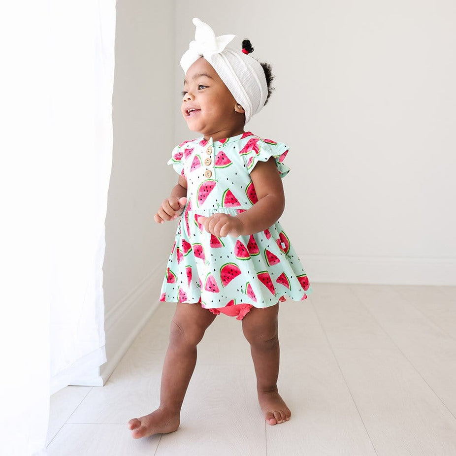 Baby in headband wearing Mellony Ruffled Cap Sleeve Henley Peplum Ruffled Bummie Set