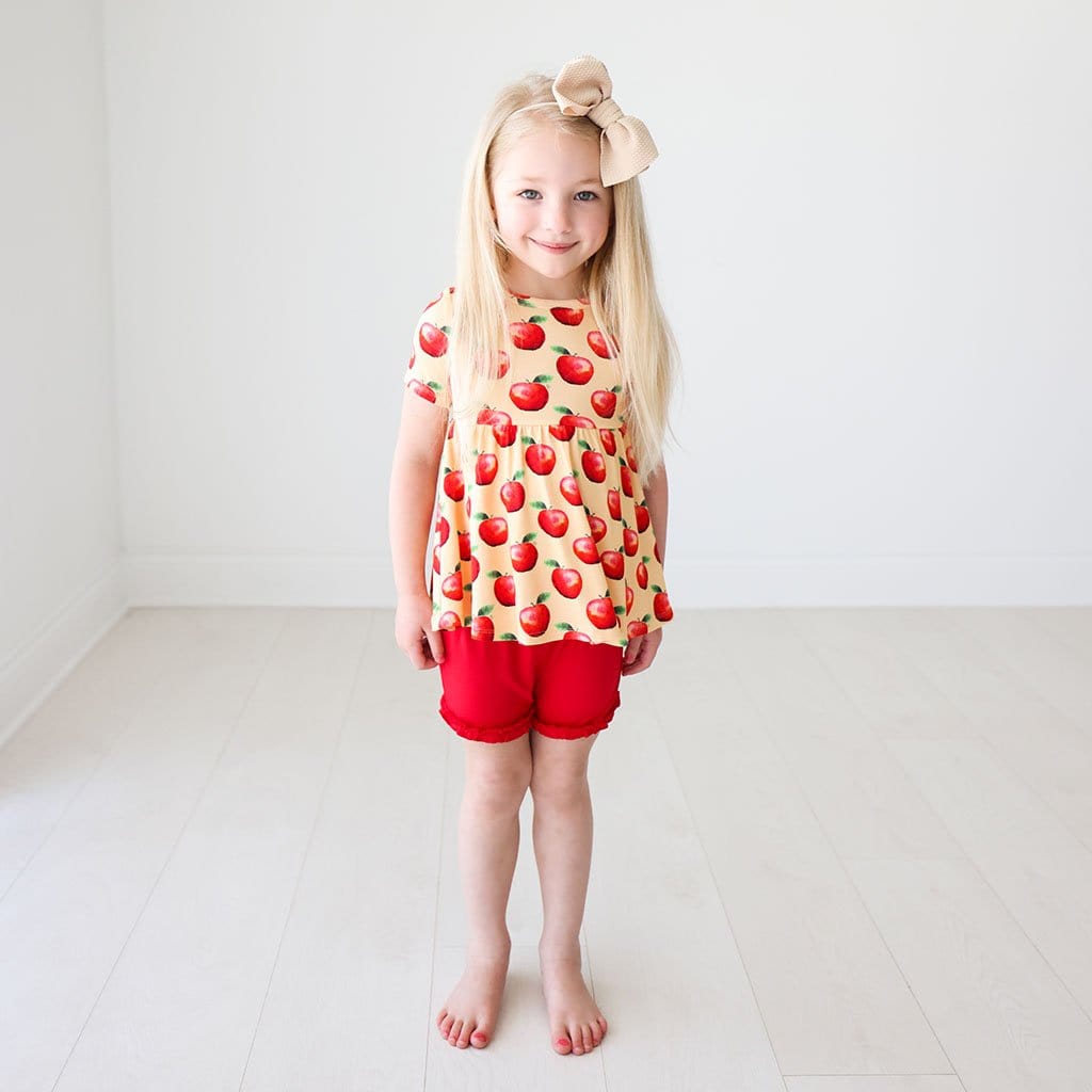 Toddler with ribbon wearing Finn Short Sleeve Peplum Ruffled Short Set