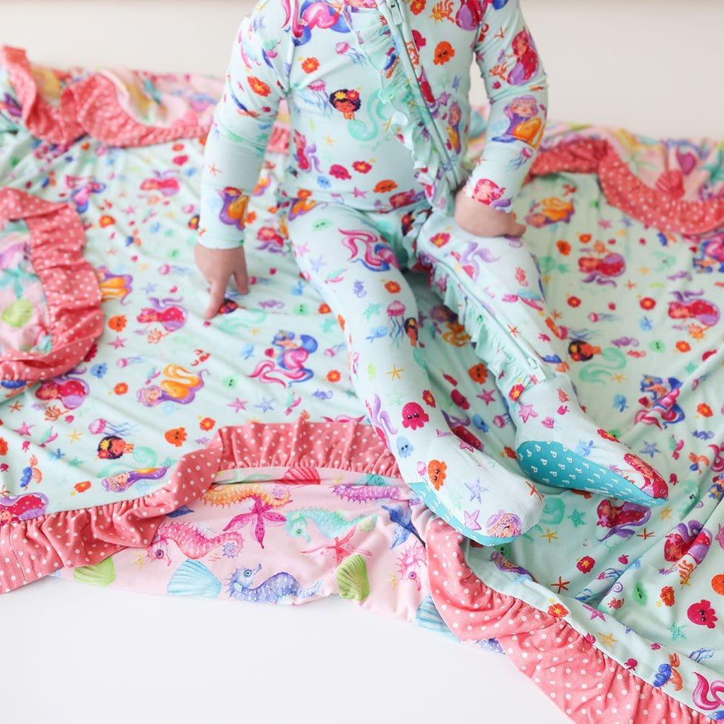 Baby sitting on Kai & Coral Ruffled Luxe Patoo in mermaid print
