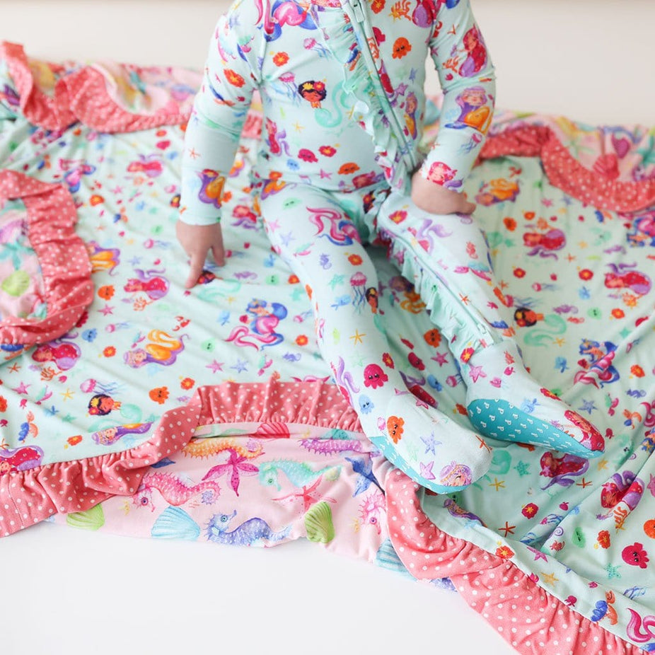 Baby sitting on Kai & Coral Ruffled Luxe Patoo in mermaid print