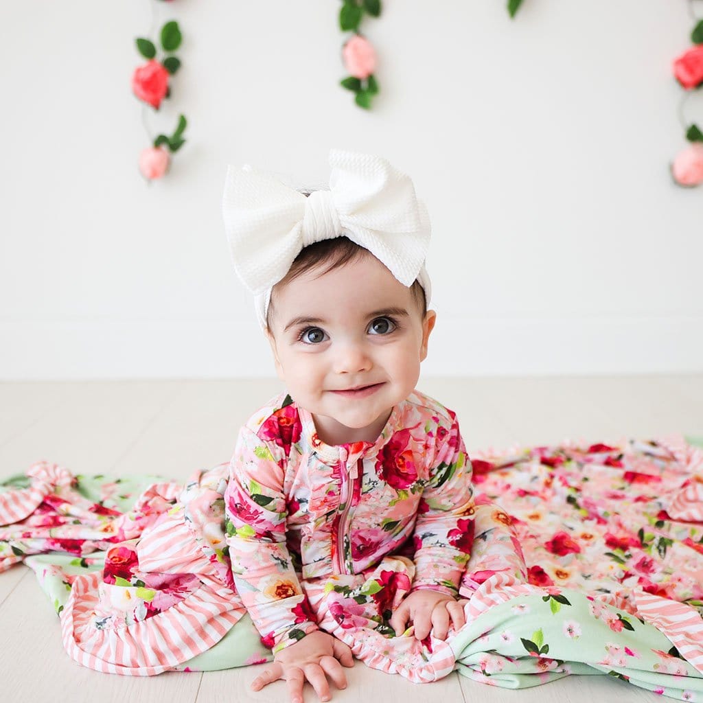 Baby in white ribbon wearing Marlene & Sylvie Ruffled Luxe Patoo