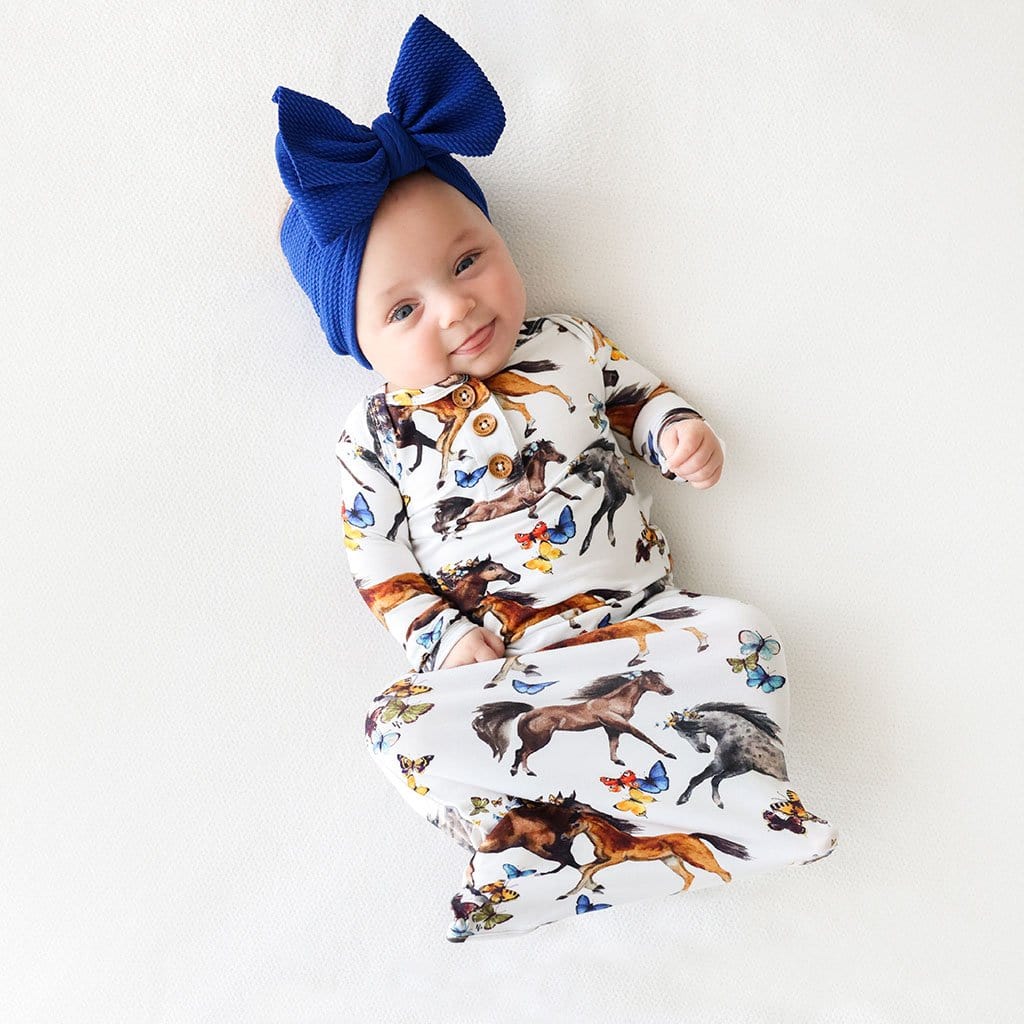 Baby wearing Claire Button Zippered Gown with animal print
