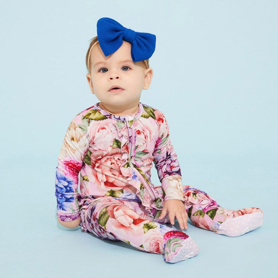 Baby in blue ribbon wearing Georgette Footie Ruffled Zippered One Piece