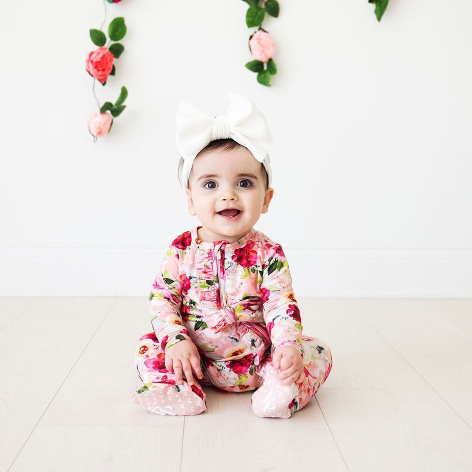 Sitting baby wearing Marlene Footie Ruffled Zippered One Piece