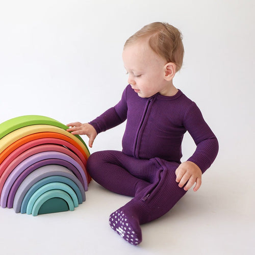 baby playing with toy in Plum Waffle Knit Baby One Piece
