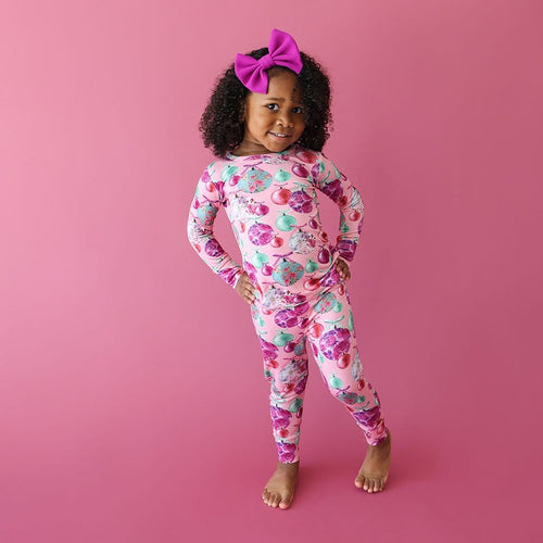 little girl with a pink ribbon posing in Christmas Toddler Pajamas | Posh Ornaments