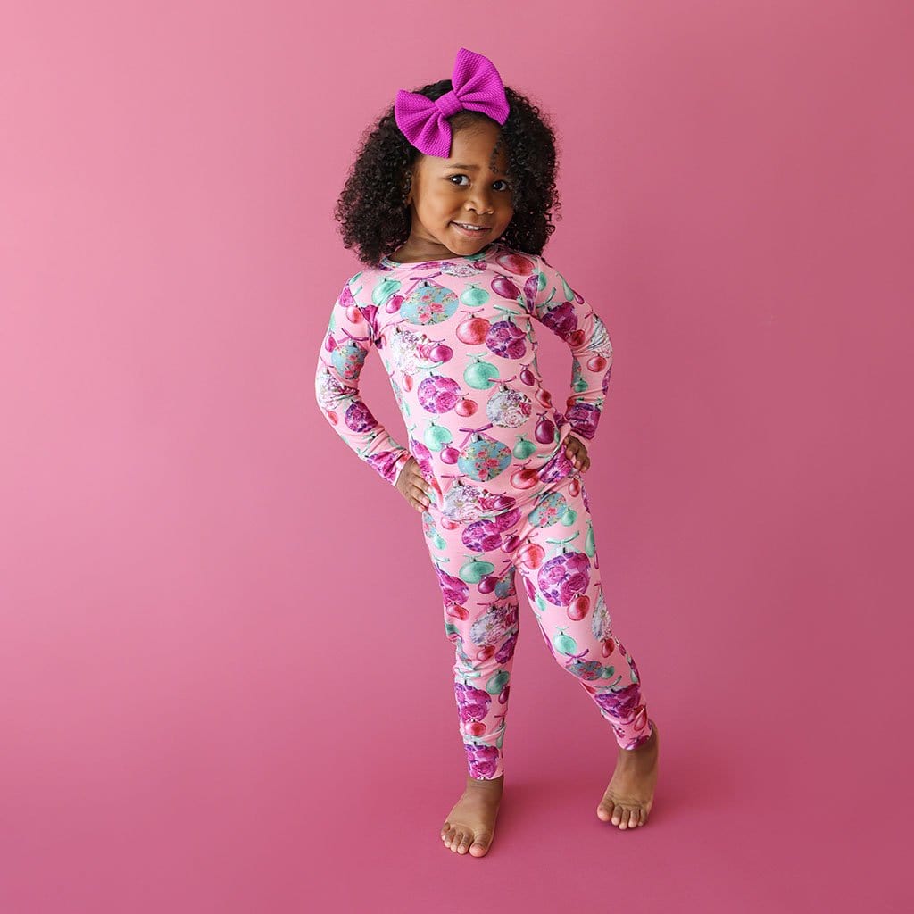 little girl with a pink ribbon posing in Christmas Toddler Pajamas | Posh Ornaments