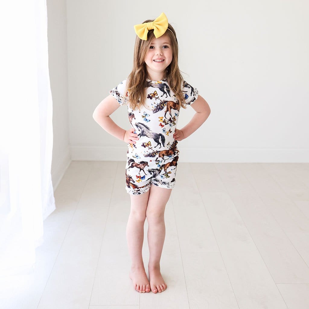 Baby in yellow ribbon wearing animal printed Claire Ruffled Short Sleeve Ruffled Short Pajamas