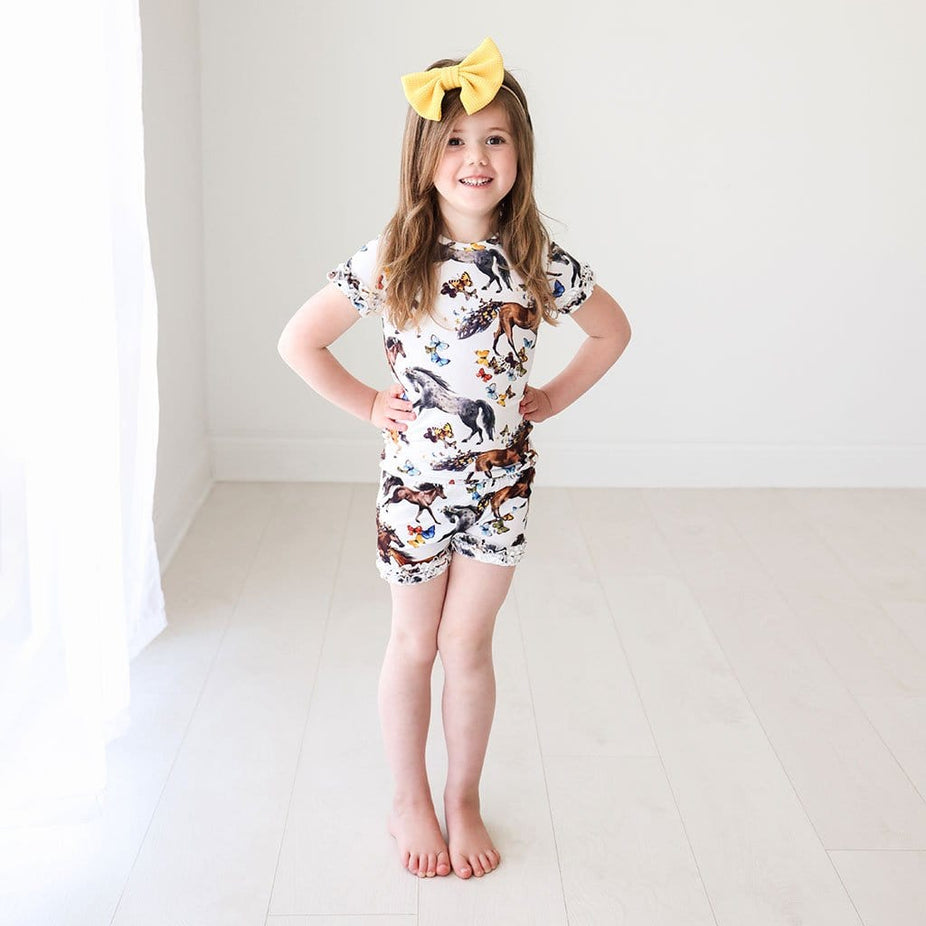 Baby in yellow ribbon wearing animal printed Claire Ruffled Short Sleeve Ruffled Short Pajamas