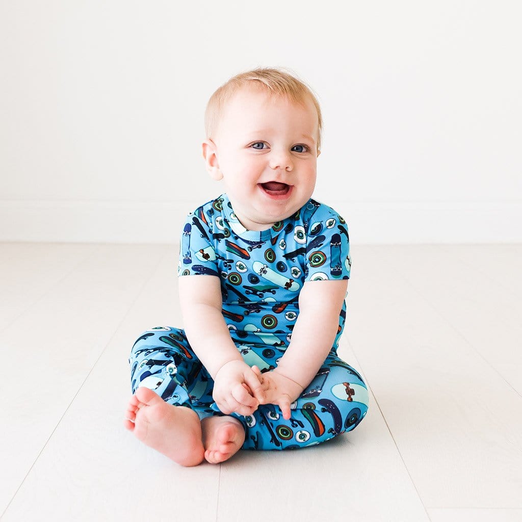 Baby wearing Cole Short Sleeve Romper in skateboard print