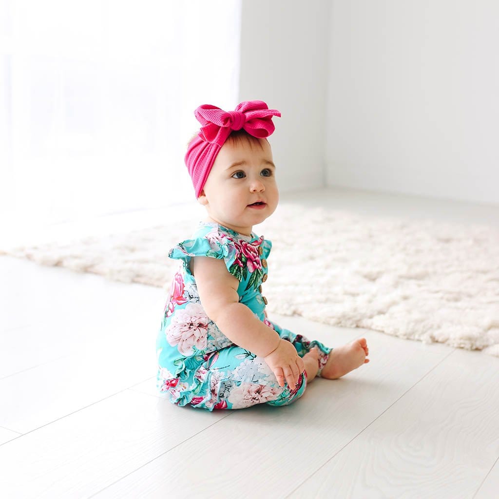 Sitting baby wearing Eloise Ruffled Cap Sleeve Henley Romper