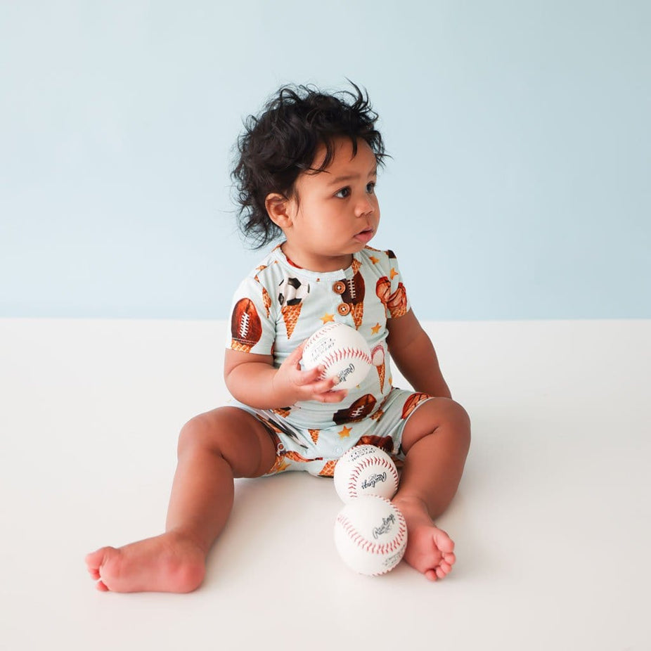Baby holding ball wearing Scoops Short Sleeve Henley Short Romper