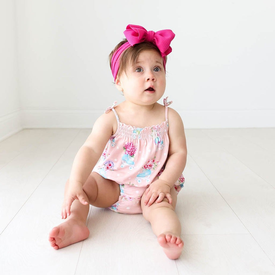 Baby in pink ribbon wearing Jenny Sleeveless Bubble Romper