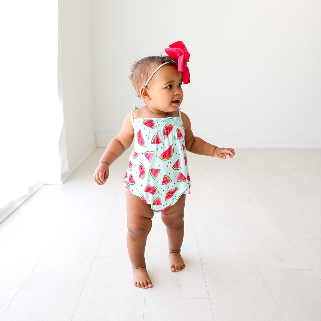 Baby standing wearing Mellony Sleeveless Bubble Romper
