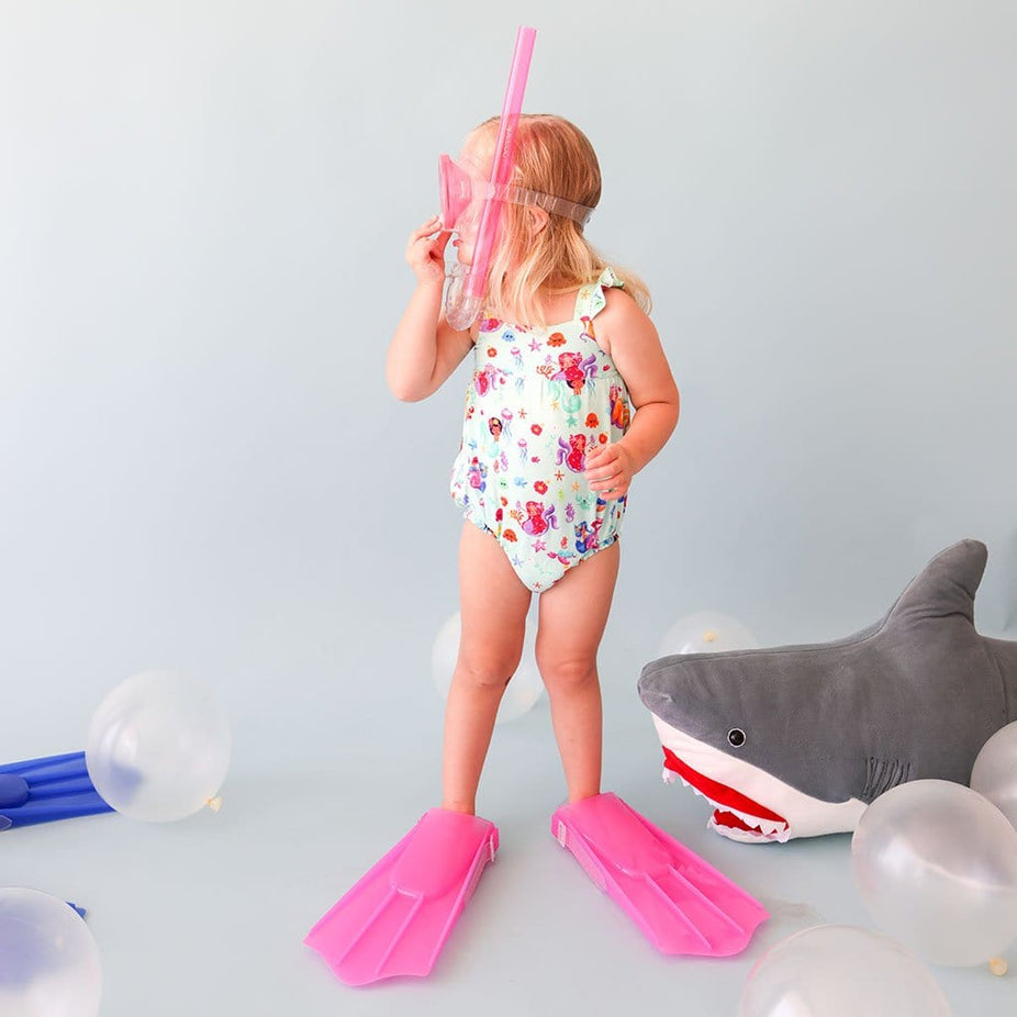 Toddler girl in flippers wearing Kai Ruffled Cap Sleeve Bubble Romper