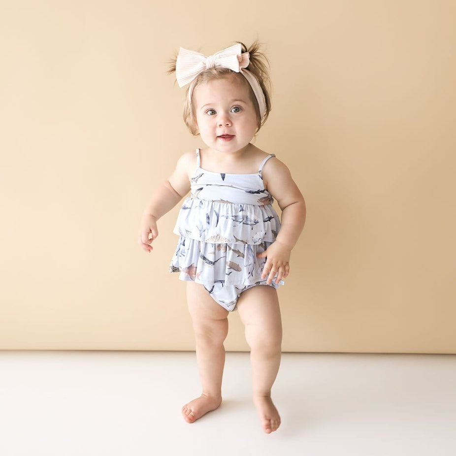 Baby in pink ribbon wearing Maverick Sleeveless Ruffled Bubble Romper