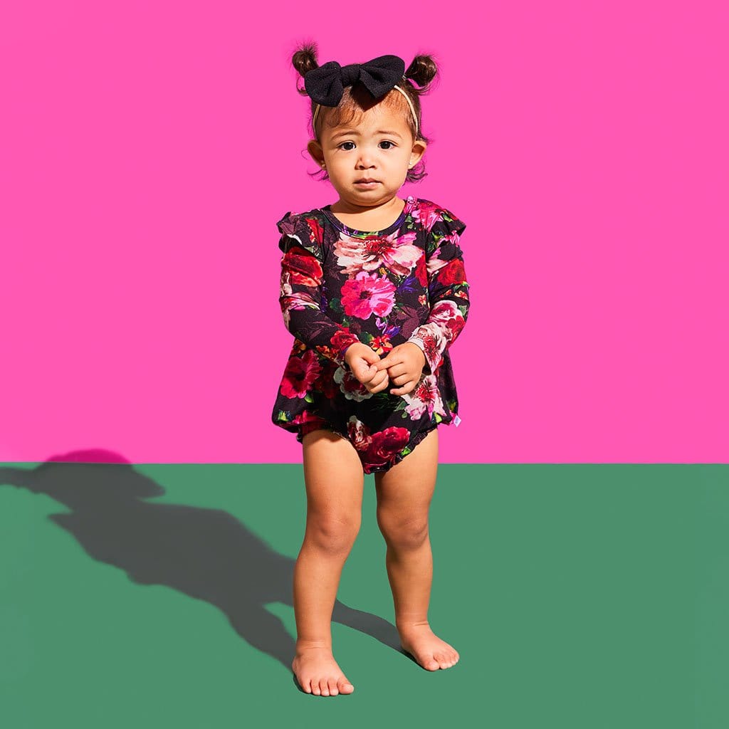 Little girl in alice + olivia® Midnight Rose Ruffled Long Sleeve Bubble Romper