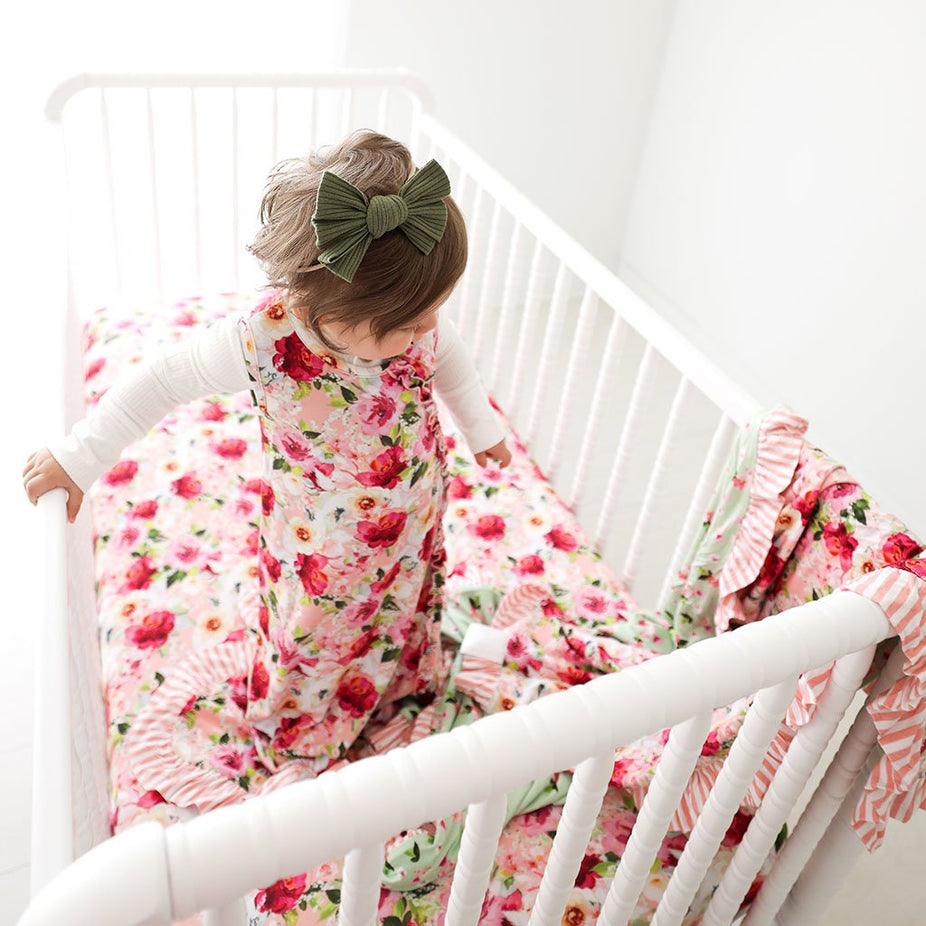 Baby in crib wearing Marlene Sleeveless Ruffled Sleep Bag 0.5 Tog with matching floral print