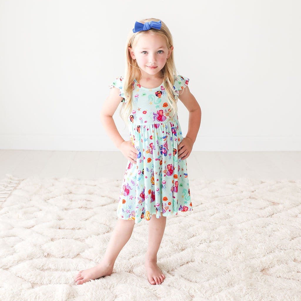 Toddler in blur ribbon wearing Kai Ruffled Cap Sleeve Twirl Dress