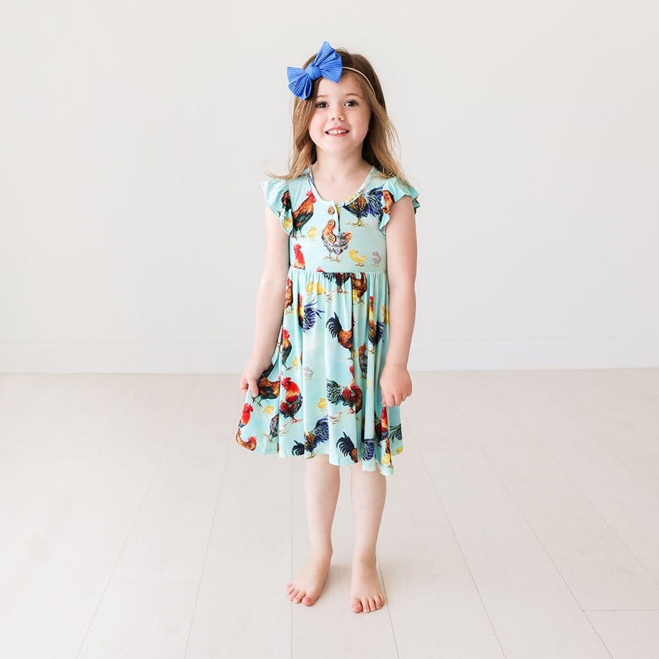 Toddler wearing Rhett Ruffled Cap Sleeve Henley Twirl Dress with chicken print