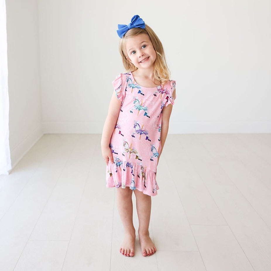 Toddler in blue ribbon wearing Claudine Ruffled Cap Sleeve Hi-Low Dress