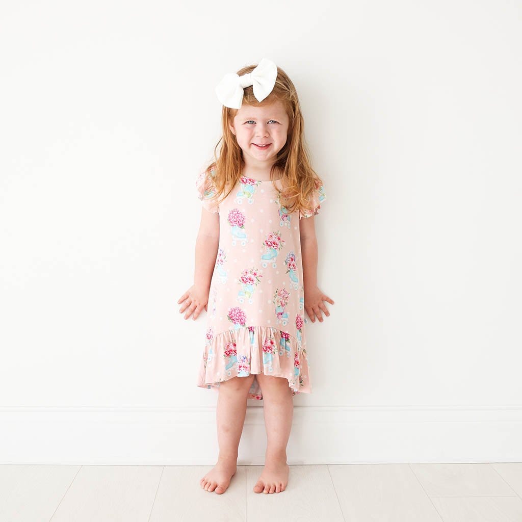 Toddler in white ribbon wearing Jenny Ruffled Cap Sleeve Hi-Low Dress