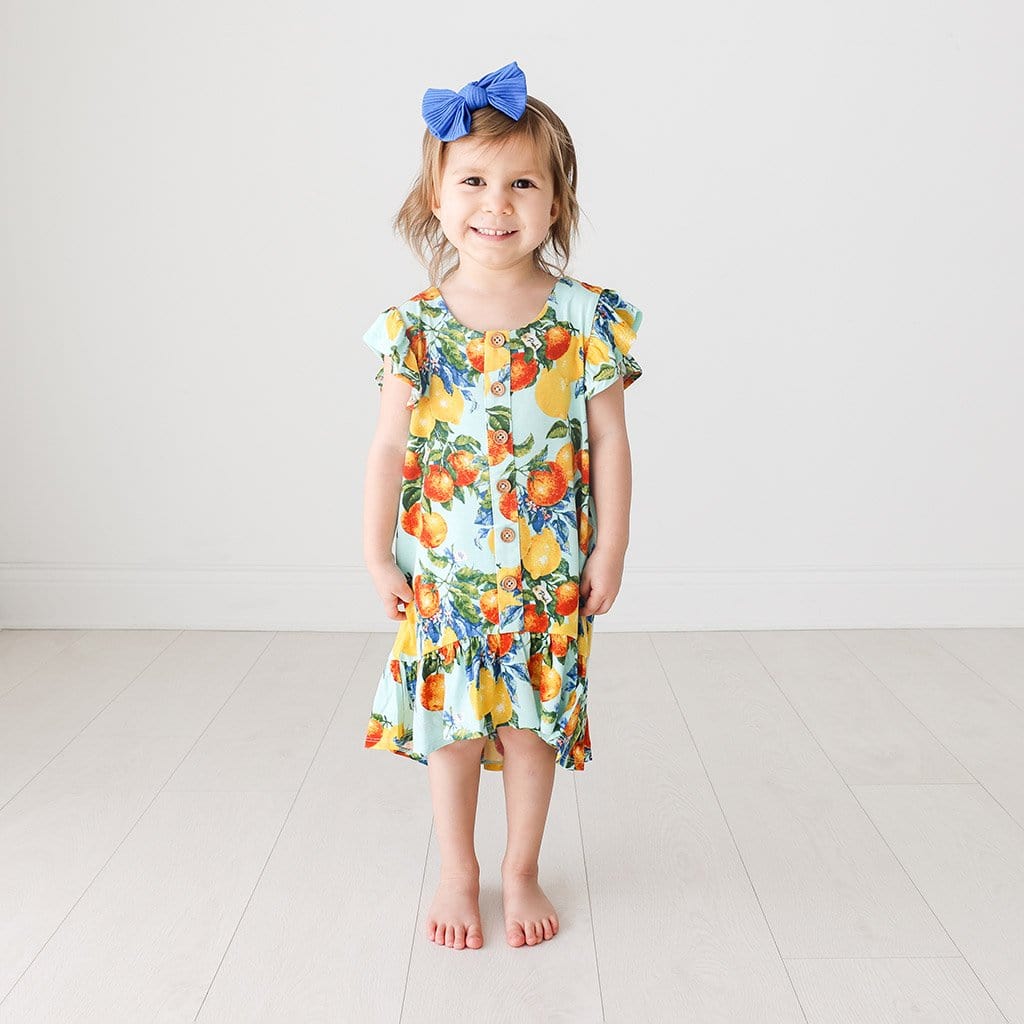 Toddler wearing Lucia Ruffled Cap Sleeve Henley Hi-Low Dress